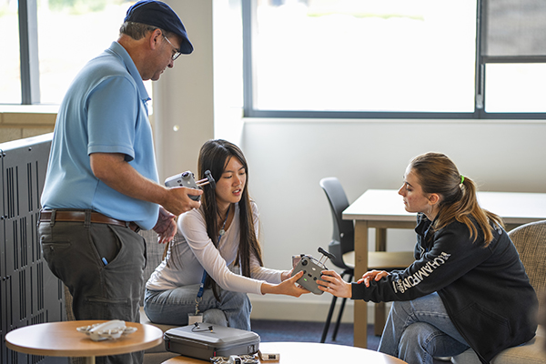 Tom McGovern, professor of mechanical engineering, works with high school students in a remote aircraft pilot class during the MOST program. width=