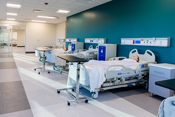 Nursing simulation lab at St. Louis Community College with hospital beds and medical equipment.