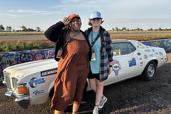 Denia Adams and a teammate stand beside their vehicle during The Great Race