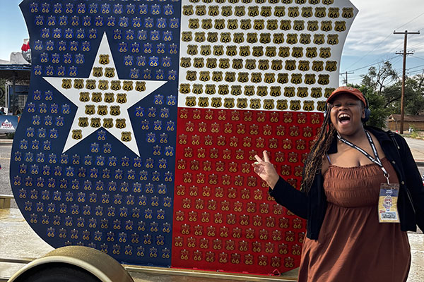 Denia Adams poses in front of Route 66 sign