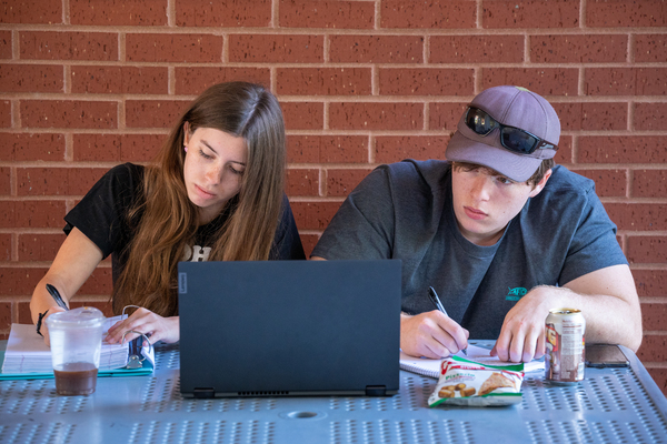 two students studying in front of laptop width=