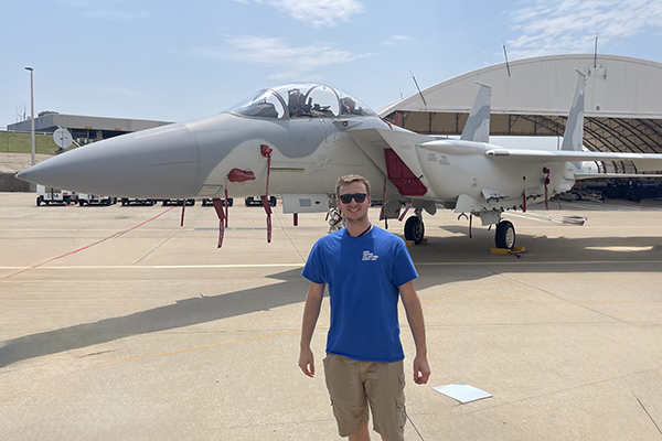 STLCC student in front of airplanes during Boeing aerospace manufacturing training in St. Louis.