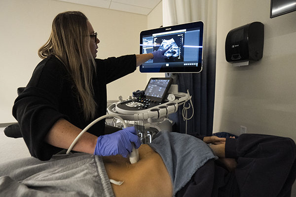 STLCC student practicing diagnostic medical sonography techniques on a patient 