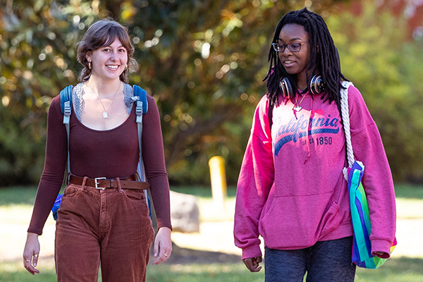Two students walking on campus width=