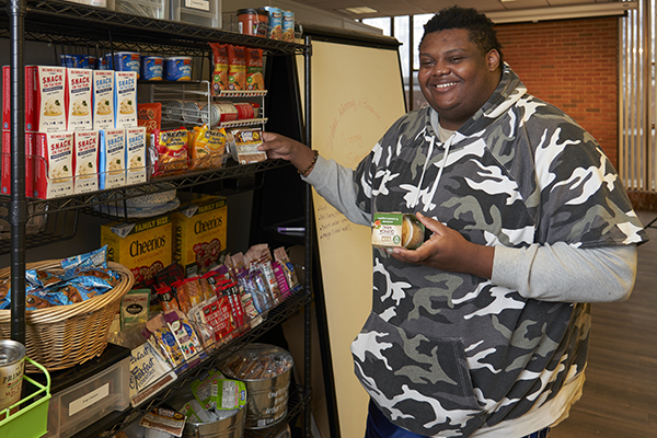 Student volunteer organizing pantry items at STLCC’s Advocacy & Resource Center width=
