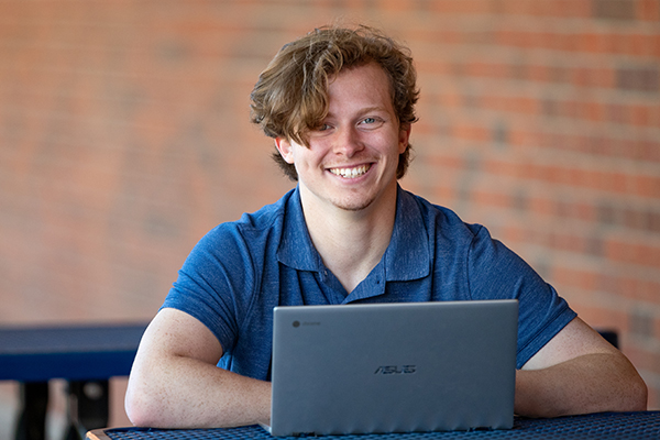 College student typing on laptop at St. Louis Community College width=