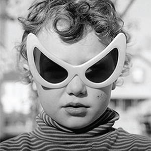 A black and white photo of a child with sunglasses