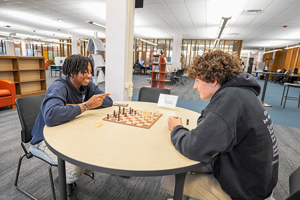 students playing chess in library