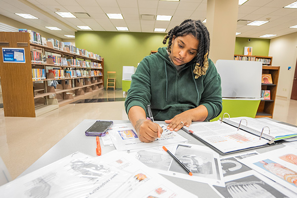 student researching paper at library