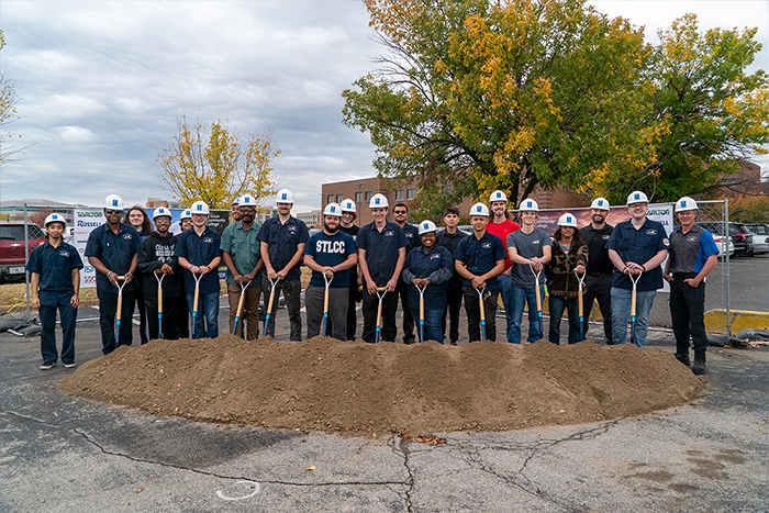 auto tech students pose behind the dirt mound