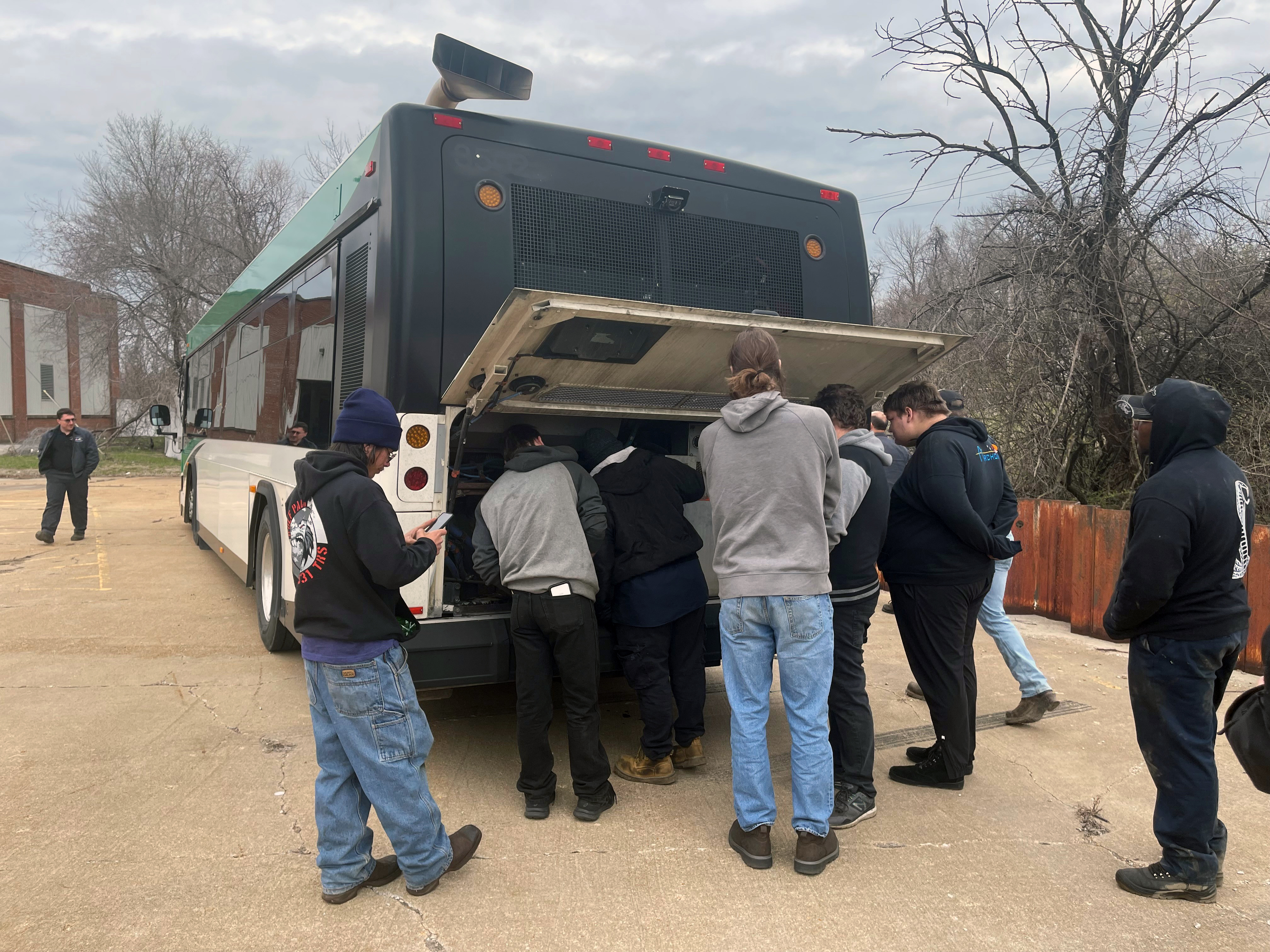 Students examine bus engine