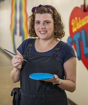 Kayla Bailey holding easel and paintbrush