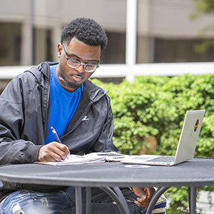 Hughes studying with laptop