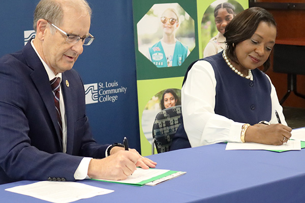 STLCC Chancellor Jeff Pittman and Girl Scouts CEO Natissia Small signing scholarship agreement