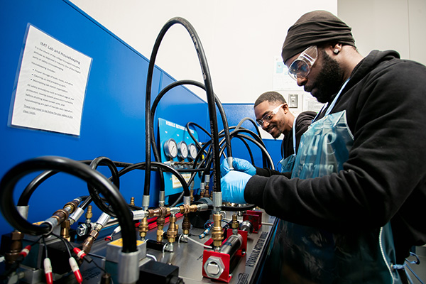 AMIOT students training with machinery