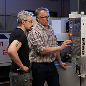 Faculty and student looking at switchboard