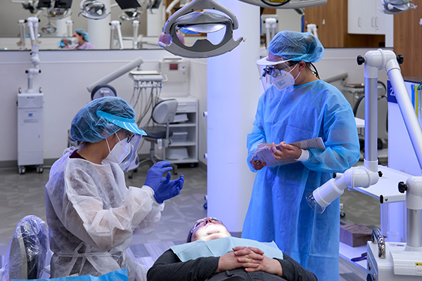 Instructor overseeing dental hygiene student training