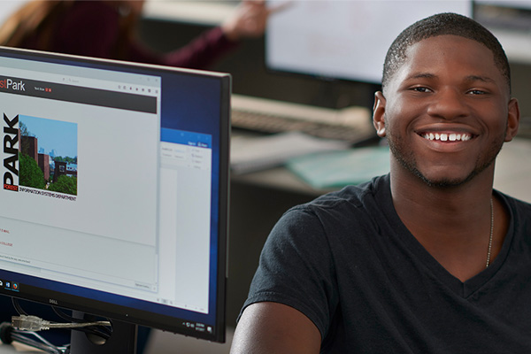  Student smiling next to computer