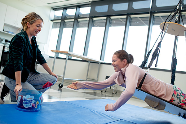 Occupational therapy students practicing techniques together using professional equipment