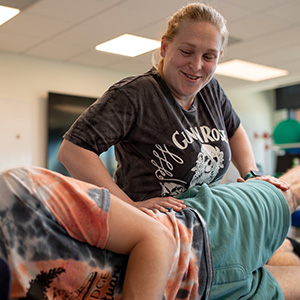 Student helping patient extend leg
