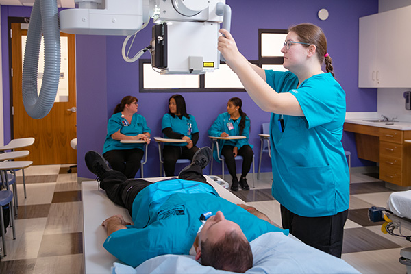 Radiologic technology student operating machinery in a clinic