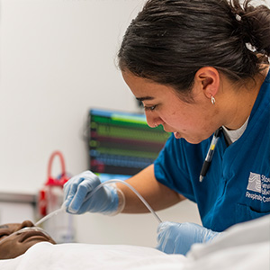 Student applying respiratory equipment to patient mannequin