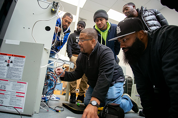Instructor demonstrating HVAC maintenance to students