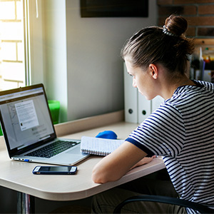 Student with notebook and laptop