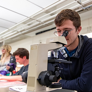 Student looking into microscope