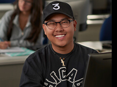 asian male medical billing and coding student in computer lab