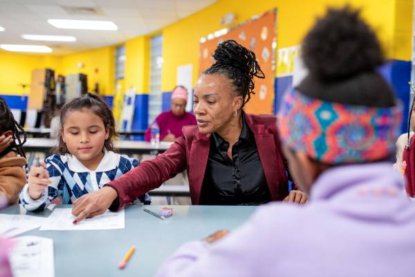 Shawntelle works with a child in the after school program