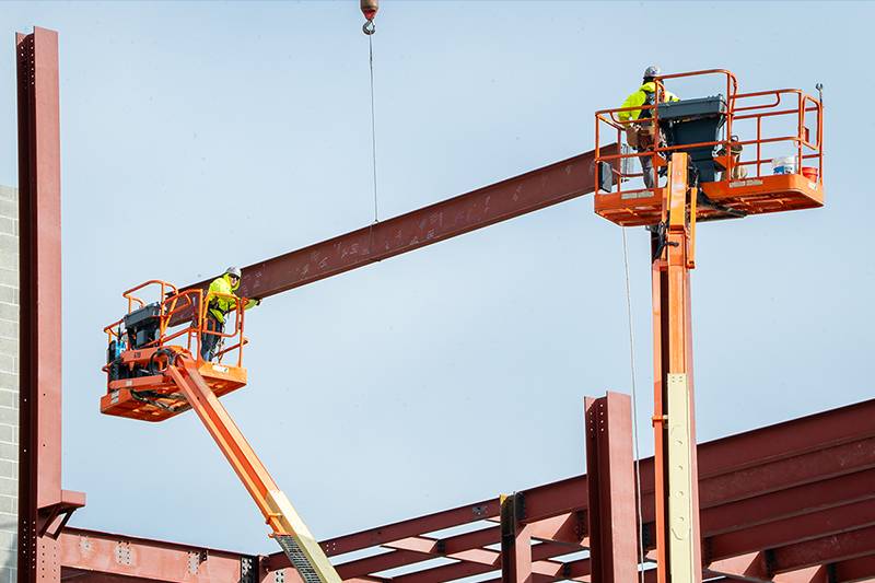 Construction workers place the signed beam into the structure