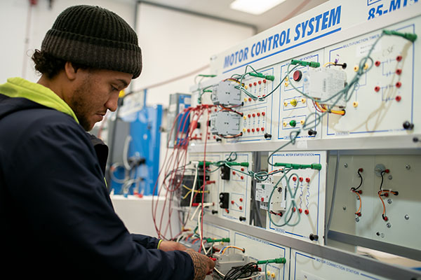  Trades student operating motor control system